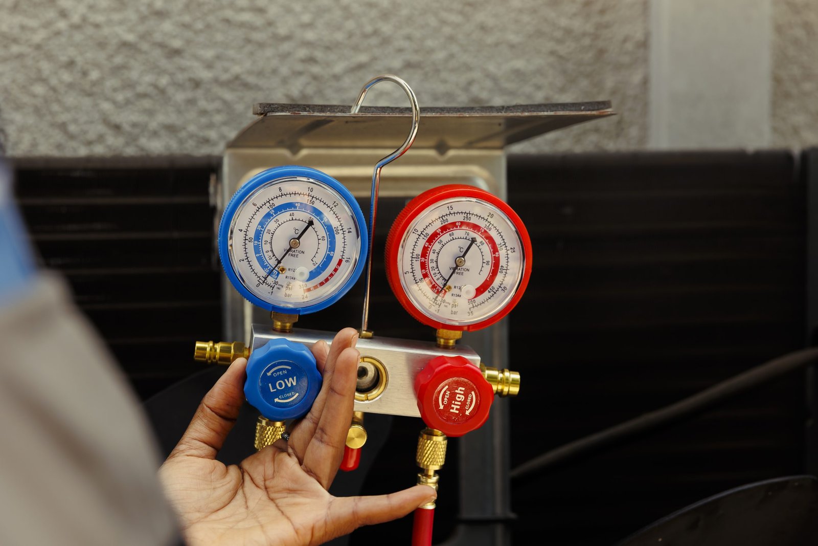 Close up of manifold gauges able to find out of order expansion valve, moisture intrusion and other hvac system internal problems. Licensed serviceman using professional gadget to read pressure levels